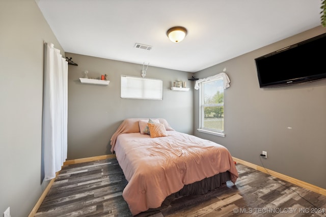 bedroom with dark hardwood / wood-style floors