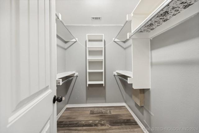 spacious closet with dark hardwood / wood-style flooring