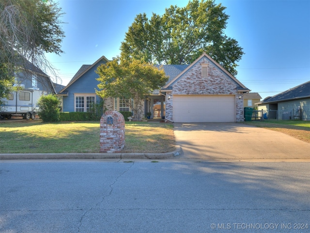 view of front of home with a front yard and a garage