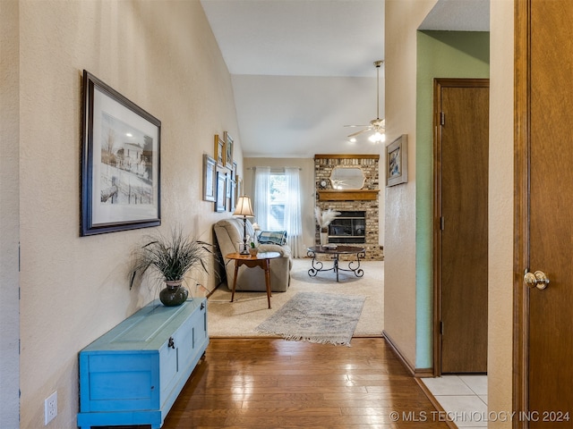 hallway with light wood-type flooring and lofted ceiling