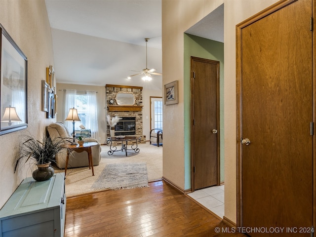 hallway with vaulted ceiling and light hardwood / wood-style flooring