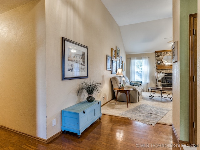 corridor featuring lofted ceiling and hardwood / wood-style floors