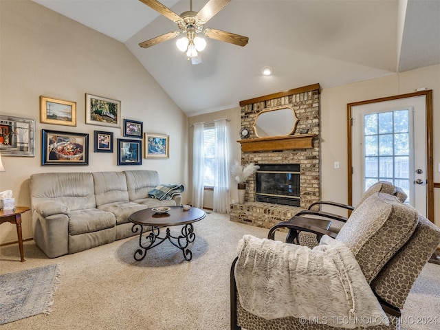 living room with a brick fireplace, ceiling fan, vaulted ceiling, and carpet flooring