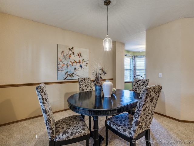 dining space with carpet flooring and a textured ceiling