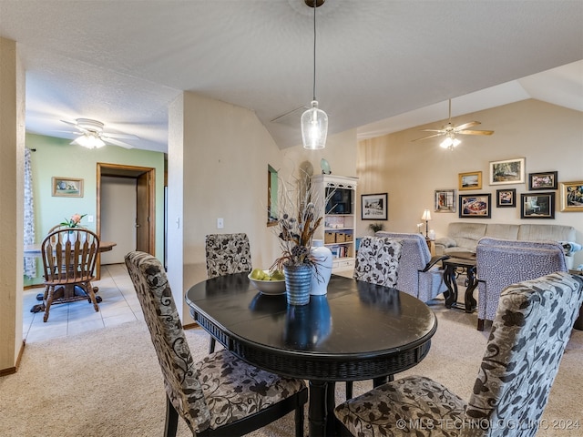 dining room with ceiling fan, light colored carpet, a textured ceiling, and vaulted ceiling