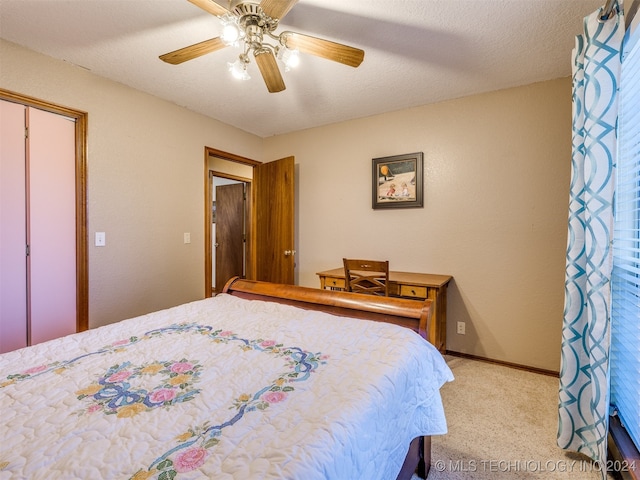 bedroom with a closet, light carpet, a textured ceiling, and ceiling fan