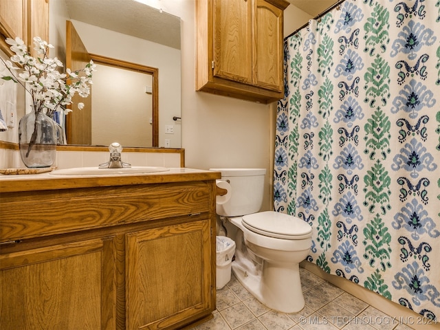 bathroom with vanity, tile patterned flooring, and toilet