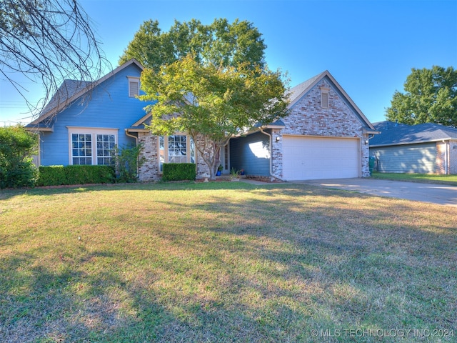 view of front of property with a front yard and a garage