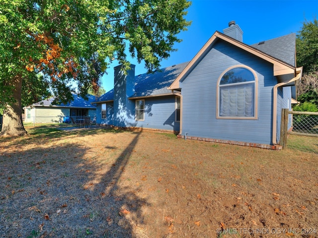 rear view of property with a yard