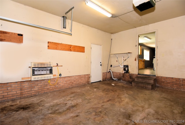 garage featuring a garage door opener and heating unit