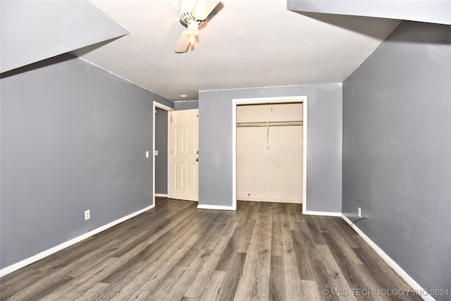 unfurnished bedroom with dark wood-type flooring and a closet