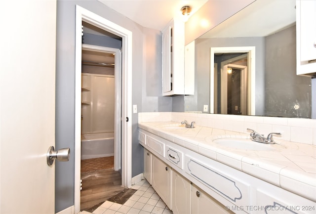 bathroom featuring bathtub / shower combination, vanity, and wood-type flooring