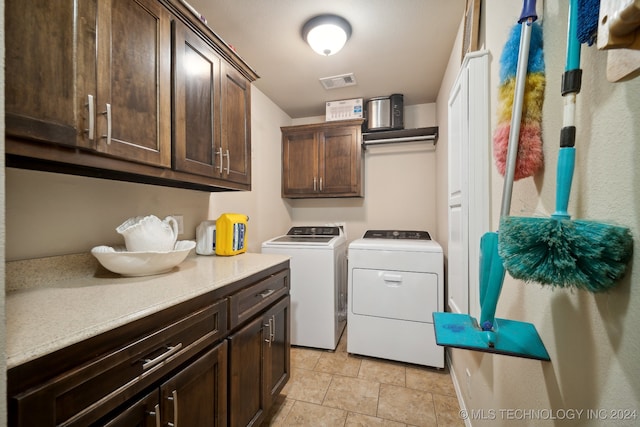 laundry room featuring separate washer and dryer and cabinets