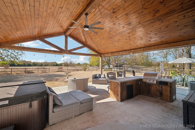 view of patio featuring area for grilling, ceiling fan, a rural view, and a hot tub