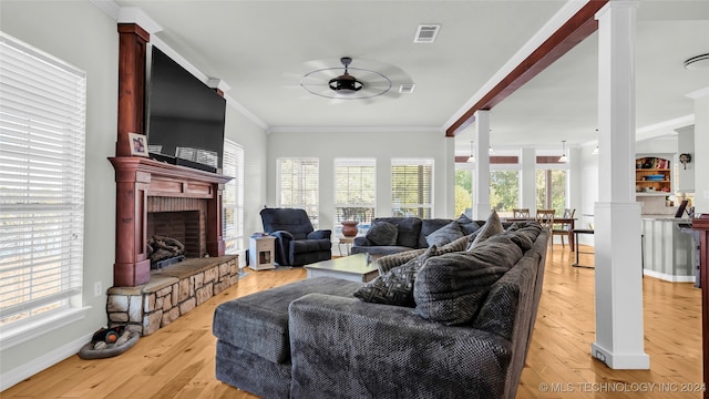 living room featuring light wood-type flooring, crown molding, and plenty of natural light