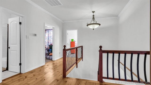 hall with light hardwood / wood-style floors and ornamental molding