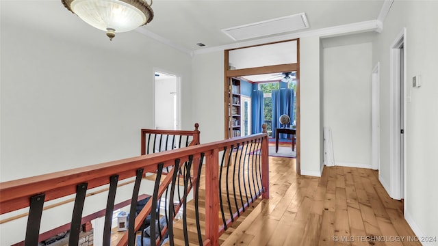 hall with ornamental molding and light wood-type flooring