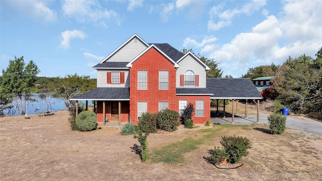 view of front of home featuring a porch, a water view, and a carport