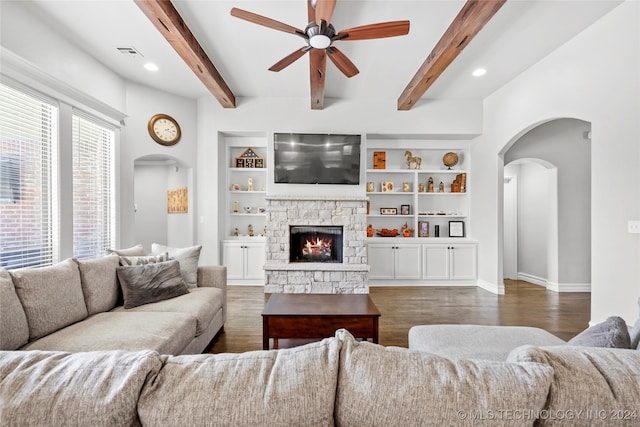 living room featuring ceiling fan, beamed ceiling, a fireplace, and dark hardwood / wood-style flooring