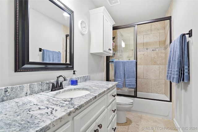 full bathroom featuring vanity, enclosed tub / shower combo, and toilet