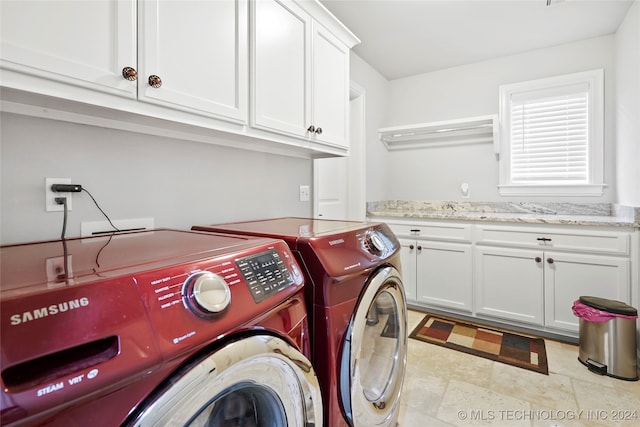 washroom featuring washing machine and dryer and cabinets