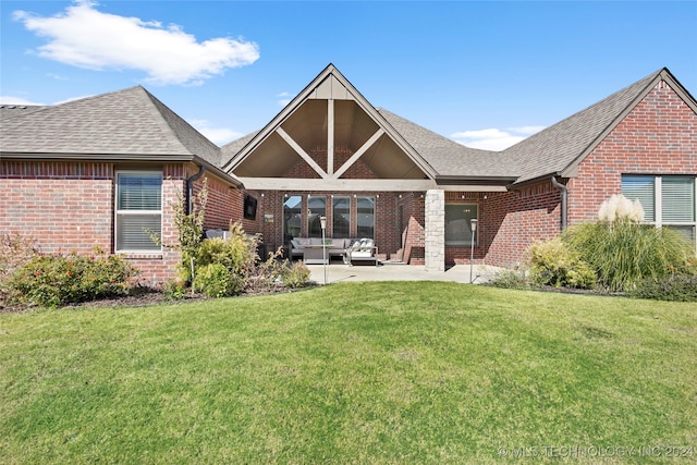 back of property with a yard and a patio