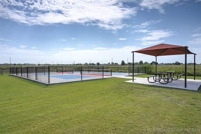 view of home's community featuring tennis court and a lawn