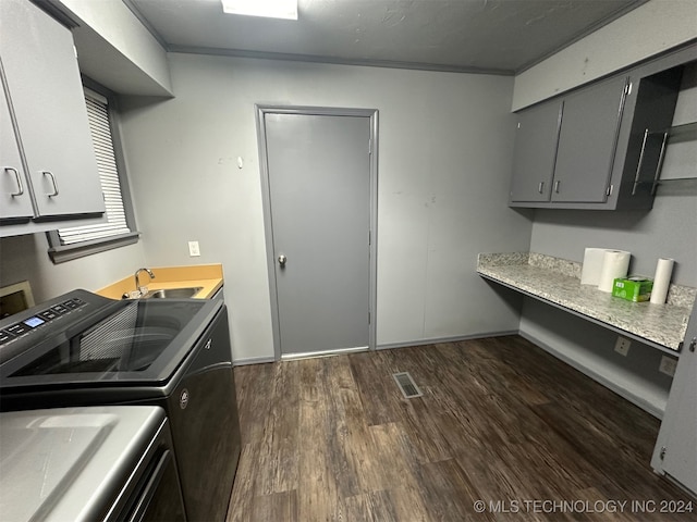 laundry area with cabinets, independent washer and dryer, dark wood-type flooring, sink, and ornamental molding