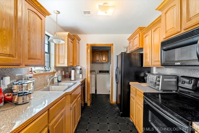 kitchen featuring washer and clothes dryer, black appliances, sink, hanging light fixtures, and light stone counters