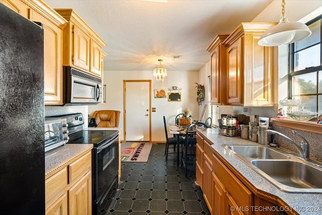 kitchen with a wealth of natural light, pendant lighting, black appliances, and sink