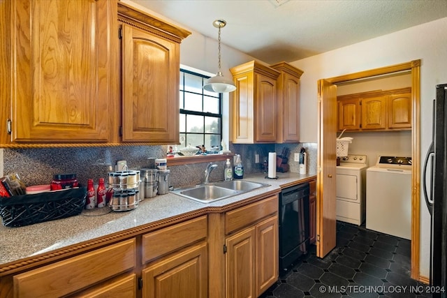 kitchen featuring sink, washer and dryer, stainless steel fridge, black dishwasher, and decorative light fixtures