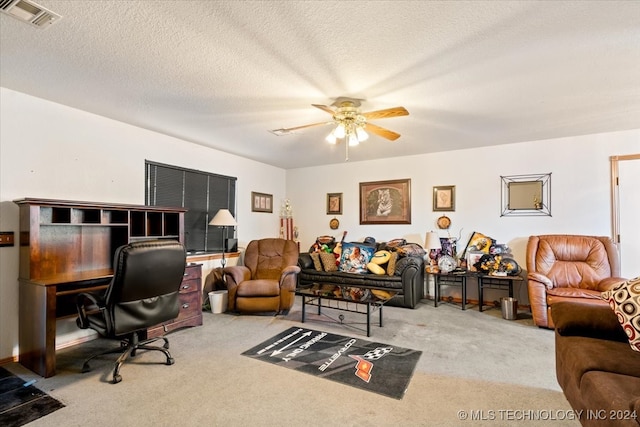 carpeted home office with a textured ceiling and ceiling fan