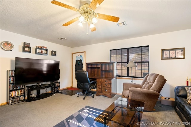 carpeted home office with ceiling fan and a textured ceiling