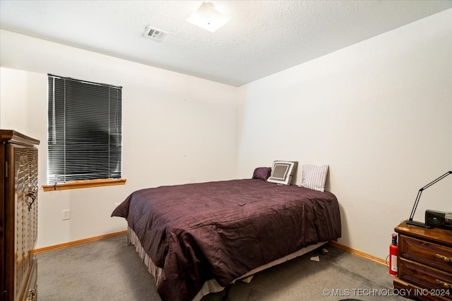 bedroom with light carpet and a textured ceiling