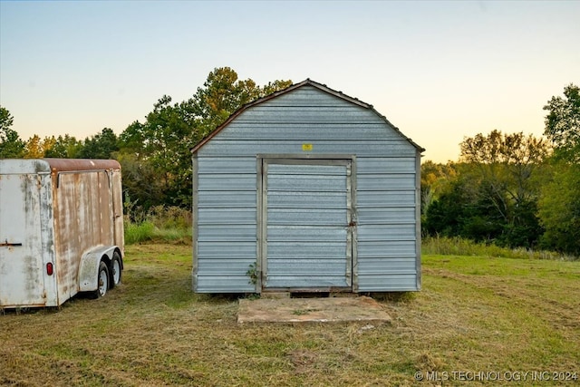 outdoor structure at dusk featuring a yard