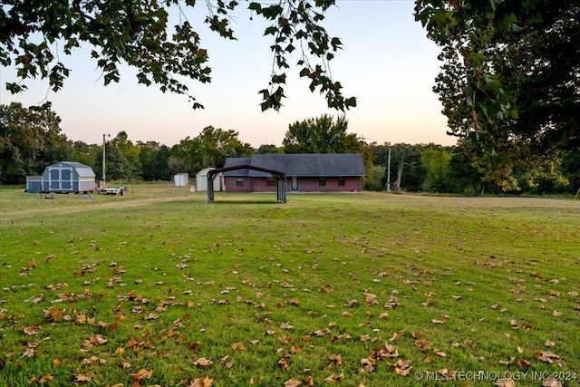 view of property's community featuring a lawn and a storage unit