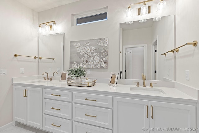 full bath featuring marble finish floor, double vanity, a sink, and baseboards