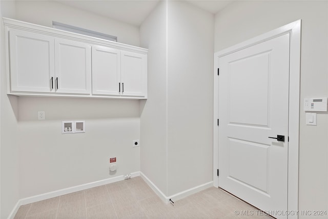 clothes washing area featuring hookup for an electric dryer, cabinets, and washer hookup