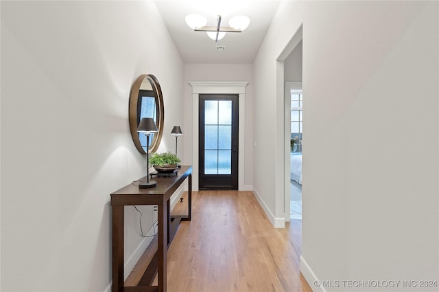 doorway to outside featuring light wood-type flooring and baseboards