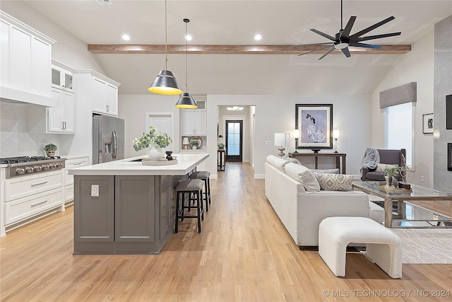 kitchen featuring white cabinets, appliances with stainless steel finishes, backsplash, and hanging light fixtures