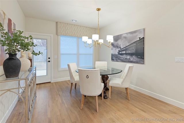 dining area featuring hardwood / wood-style flooring, a wealth of natural light, and a chandelier