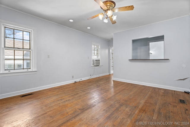 empty room featuring hardwood / wood-style flooring, ceiling fan, cooling unit, and crown molding