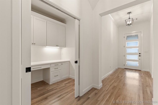 interior space with a notable chandelier, crown molding, and light hardwood / wood-style floors