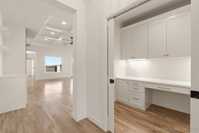 hall with light hardwood / wood-style floors, beamed ceiling, and coffered ceiling