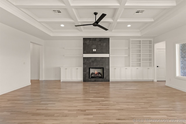 unfurnished living room featuring a fireplace, beamed ceiling, coffered ceiling, and light wood-type flooring