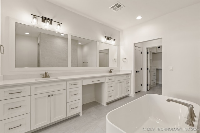 full bathroom featuring a freestanding tub, visible vents, a sink, and double vanity