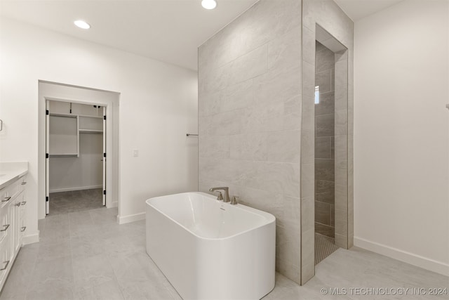 bathroom with vanity, tile walls, and separate shower and tub