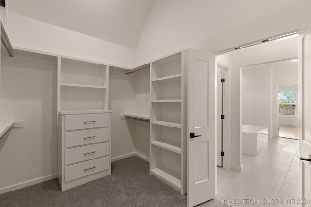 spacious closet featuring lofted ceiling and light tile patterned flooring