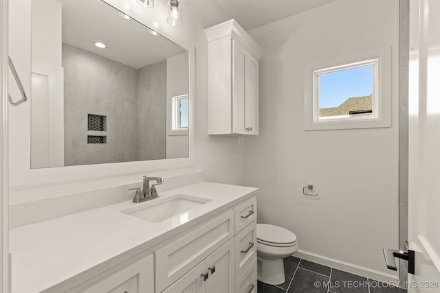 bathroom with toilet, tile patterned flooring, vanity, and baseboards