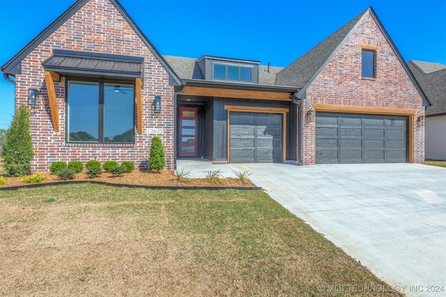 view of front facade with a front yard, brick siding, and driveway